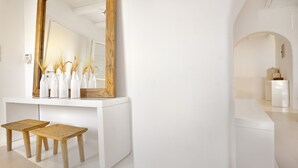 A modern bathroom with a large mirror, wooden stools, and a white vanity. - Villa Blanca Duo (Mykonos)