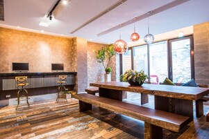 Una cocina moderna con encimera de madera, dos taburetes de bar, un banco de madera y lámparas colgantes.