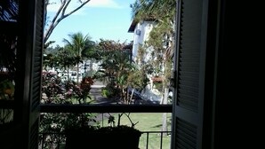 A balcony with a view of a residential area, including houses and trees. - Apartamento Piccola Porto Bracuhy (Angra dos Reis)