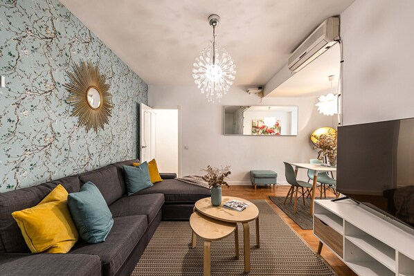 A modern living room with a sectional sofa, a round coffee table, and a TV.