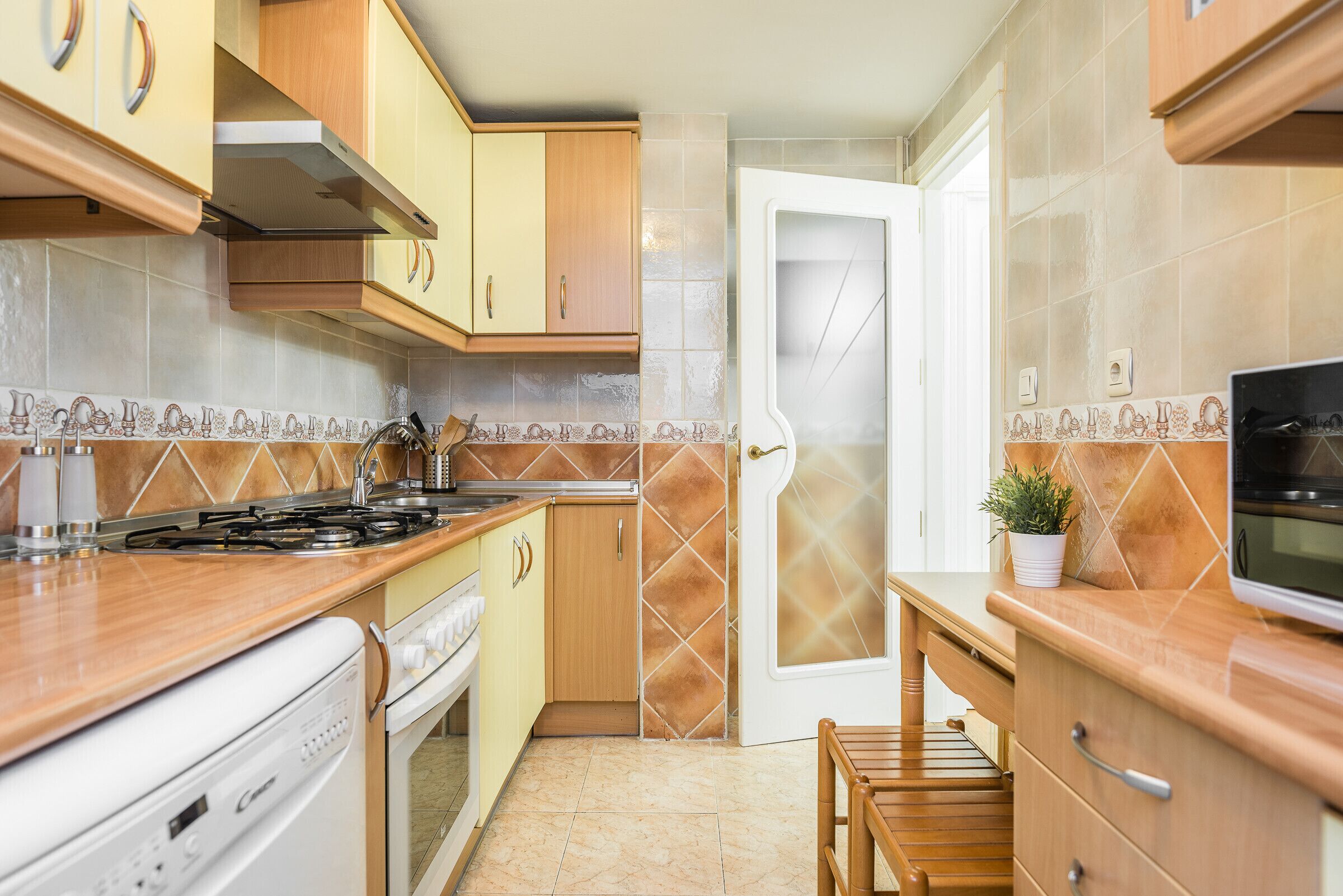 A kitchen with wooden cabinets, a stove, and a microwave.