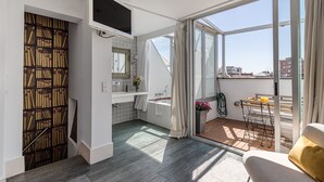 Un apartamento moderno con balcón, cocina con estantería empotrada y vistas a la ciudad.