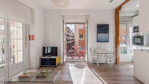 Een modern appartement met een woonkamer, eethoek en keuken.