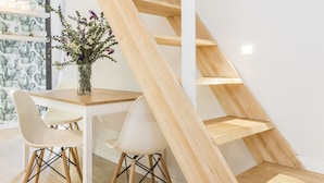 A modern staircase with wooden steps and white railings, leading to an upper floor. - Waou Sol III - Alquiler de Corta Duración (Madrid)