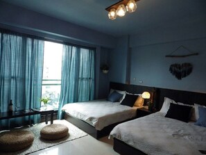 A bedroom with two beds, a window with curtains, a bedside table with a lamp, and a hanging heart decoration. - Woods Decor (Tainan)