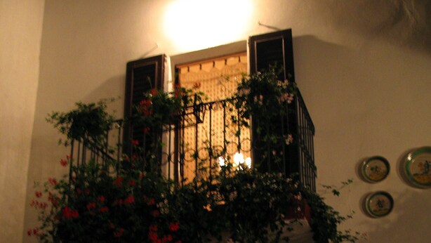 Ein schwach beleuchteter Raum mit Balkon, Kamin und Wandgestaltungen.