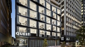 A modern hotel with multiple floors, large windows, and a prominent "QUEST" sign at the entrance. - Quest North Sydney (North Sydney)