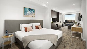 A modern hotel room with a large bed, a desk, and a TV. - Quest North Sydney (North Sydney)
