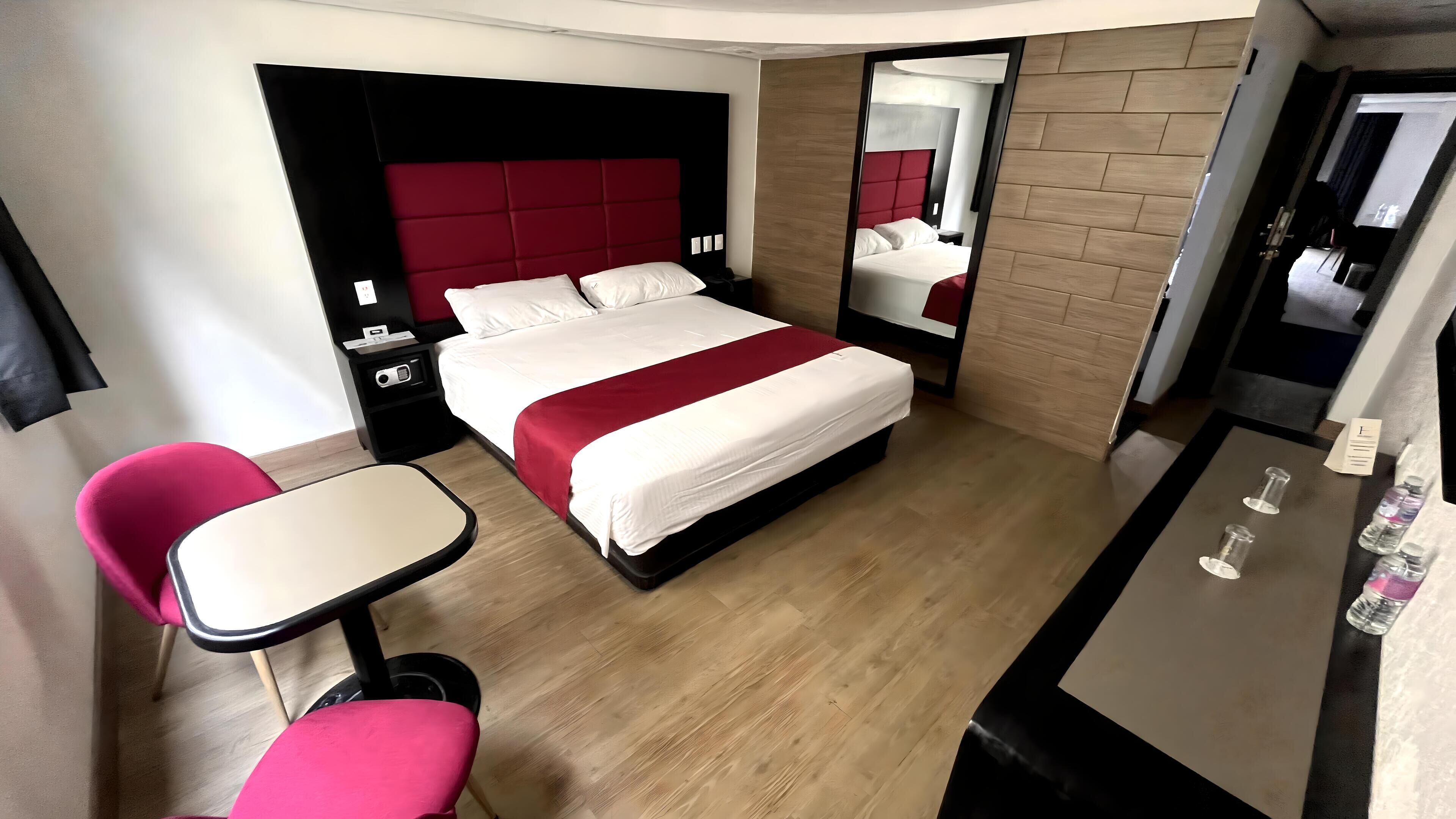A modern hotel room with a large bed, a desk, and a chair.