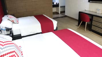 Habitación de hotel con dos camas, un escritorio y una silla.