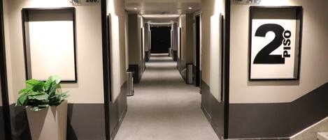 A hotel corridor with a sign indicating room number 2 Piso.