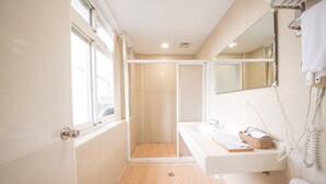 Ein Badezimmer mit Dusche, Waschbecken und Toilette.