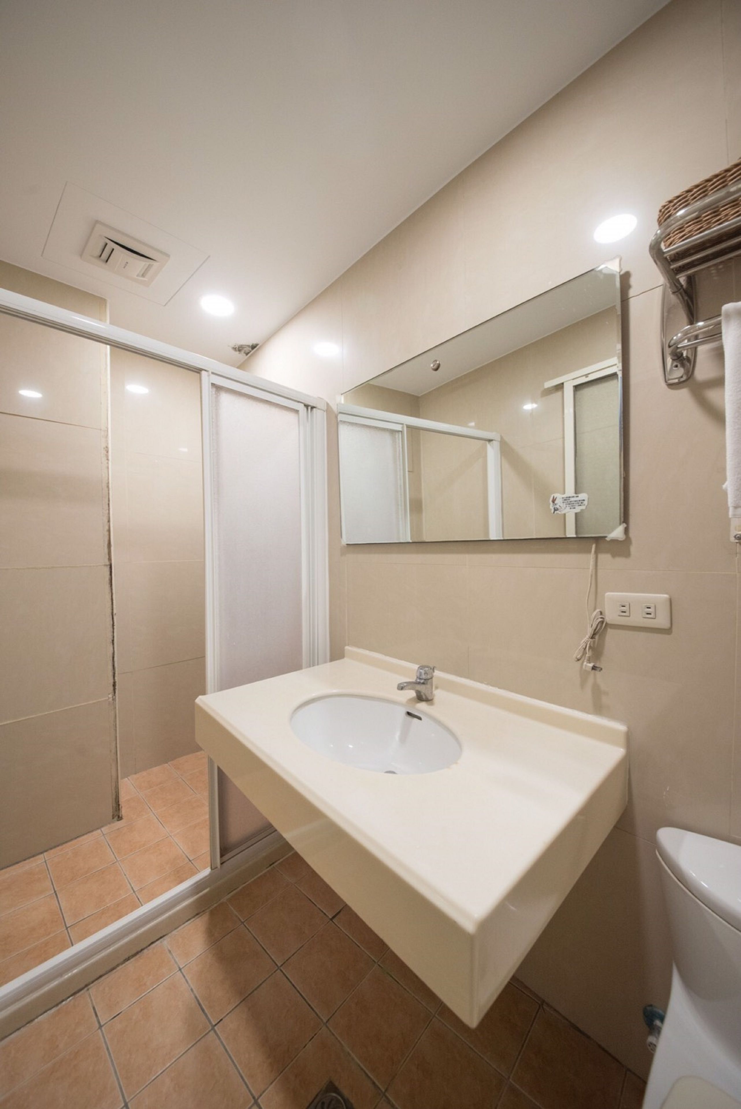 A bathroom with a white sink, mirror, and toilet.