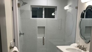 A modern bathroom with a glass-enclosed shower, a white sink, and a toilet. - Carriage House in Tarrytown - Central Austin, New in 2018 (Austin)