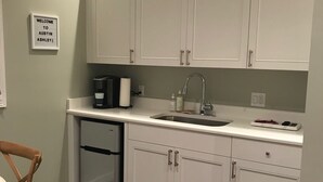 A kitchen with white cabinets, a sink, a coffee maker, and a dishwasher. - Carriage House in Tarrytown - Central Austin, New in 2018 (Austin)