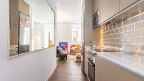 A narrow kitchen with a herringbone floor, a built-in oven, and a microwave. - Waou Sol es MIA - Corta Duración (Madrid)