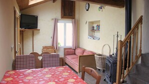 Une pièce confortable avec un lit, un canapé, une télévision et une cheminée.
