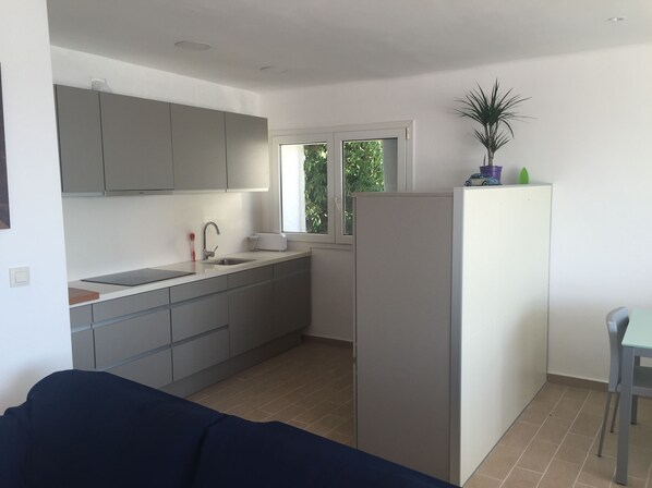 A compact kitchen with grey cabinets, a sink, and a window. - L'Estartit Apartment (Estartit)