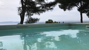 Une piscine aux eaux cristallines, offrant une vue sur les montagnes et les arbres qui se dressent à l'horizon.