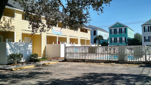 A row of colorful motel buildings with a fenced pool area in the foreground. - COMPLETELY RENOVATED! Immaculately clean and new. See new photos! (Surfside Beach)