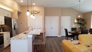 A modern kitchen with a marble countertop, stainless steel appliances, and pendant lighting. - Walk to beach! Cottage perfect for families. (Kill Devil Hills)