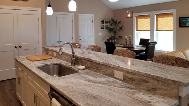 A kitchen with a marble countertop, stainless steel sink, and pendant lights. - Walk to beach! Cottage perfect for families. (Kill Devil Hills)