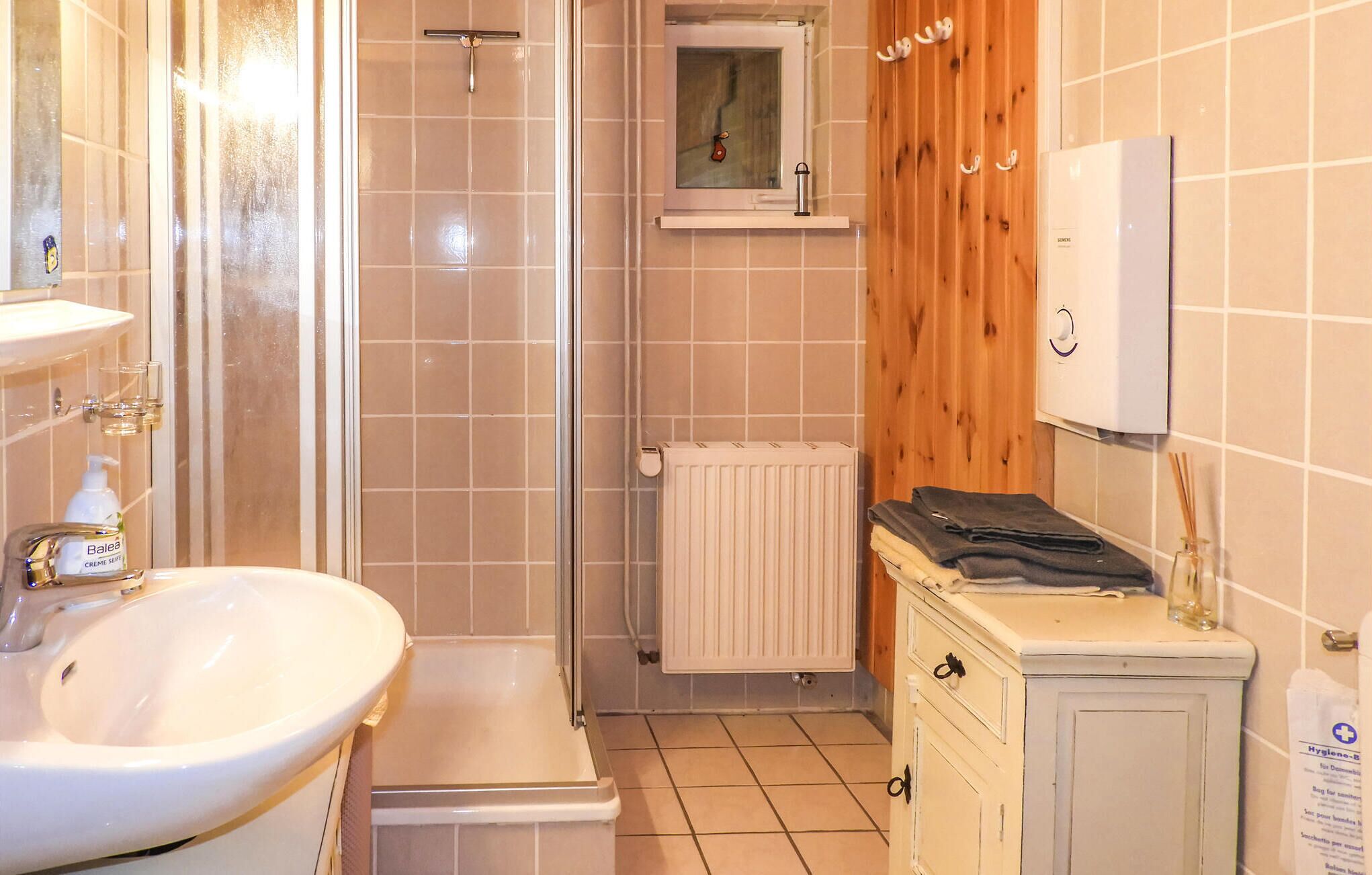 A bathroom with a sink, shower, and toilet.