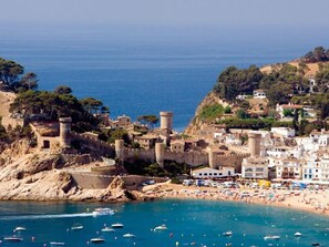 A coastal town with historic stone buildings, a fortified castle, and a beach with boats. - Studios very close to the beach. Ref.LLORET SUN-2 (Lloret de Mar)