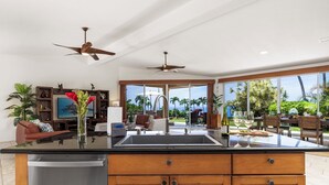 Una cocina moderna con una isla grande, armarios de madera y vistas al exterior.