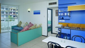 A compact living space with a kitchenette, a dining area, and a sofa with cushions. - Apartments very close to the beach. Ref.LLORET SUN-24 (Lloret de Mar)