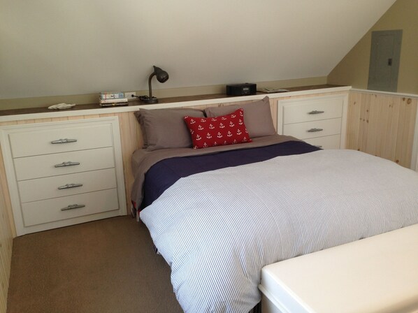 Un dormitorio con cama, escritorio y silla.