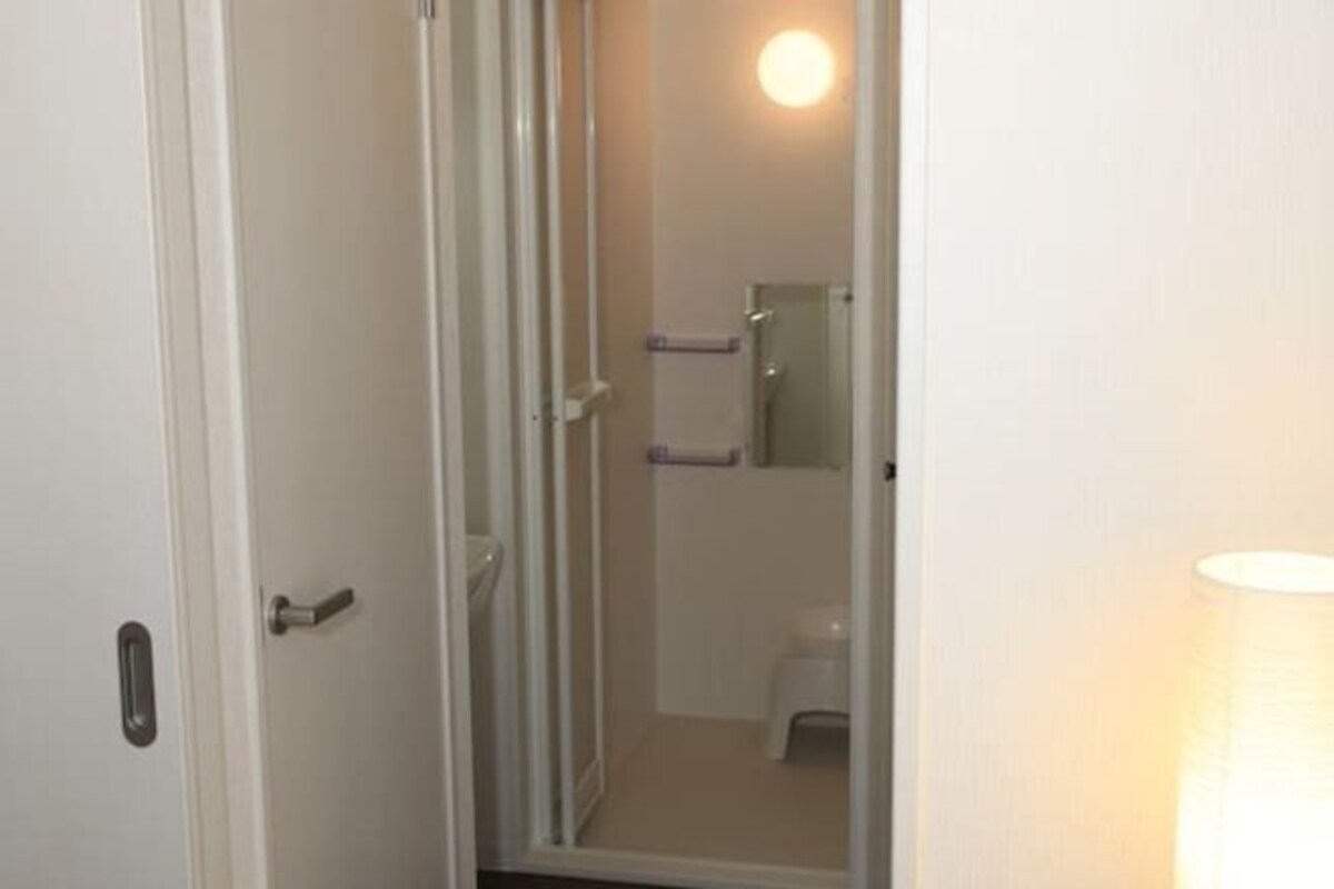 A bathroom with a toilet, a mirror, and a towel rack.