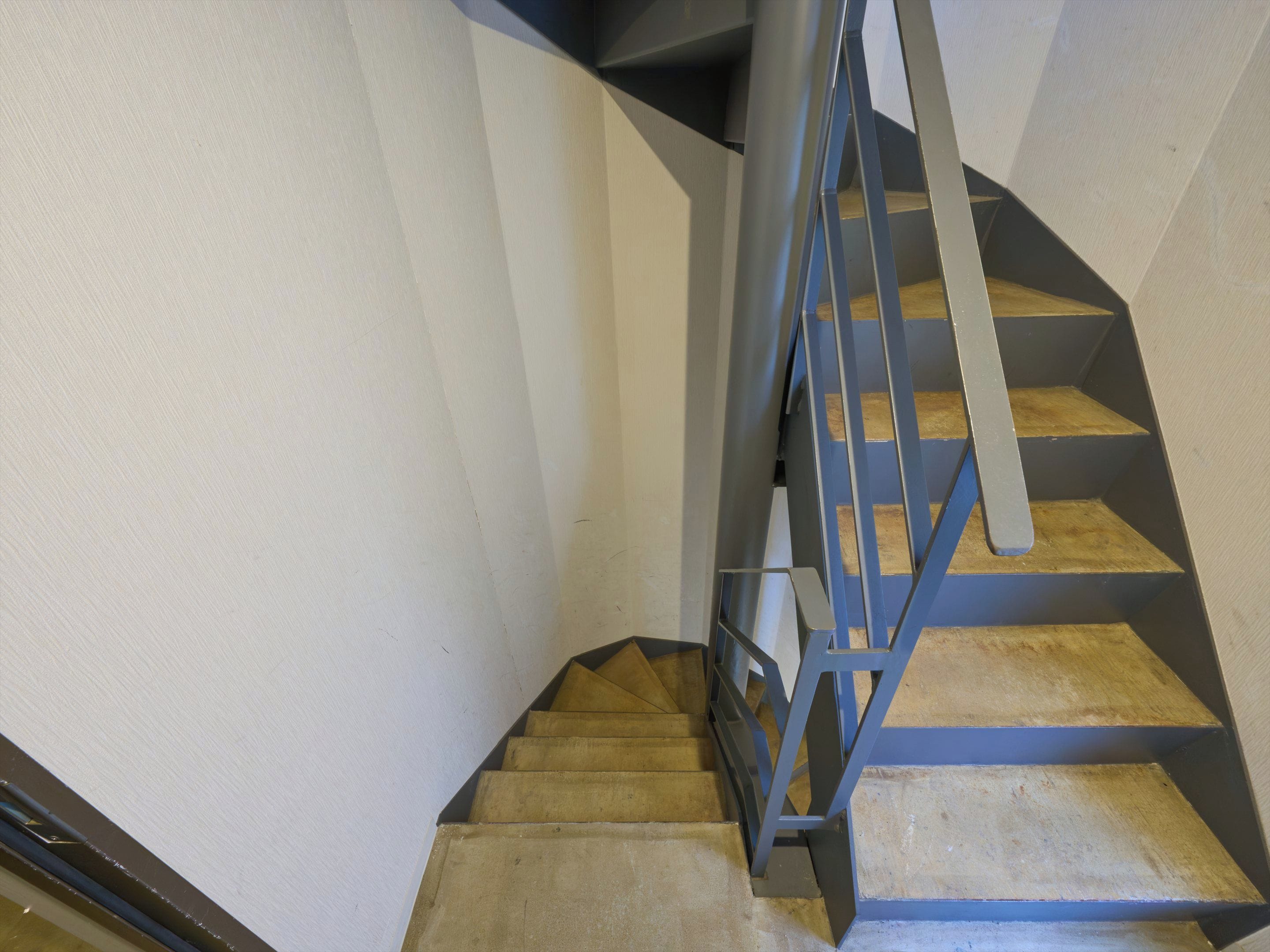A staircase with a metal handrail and wooden steps.