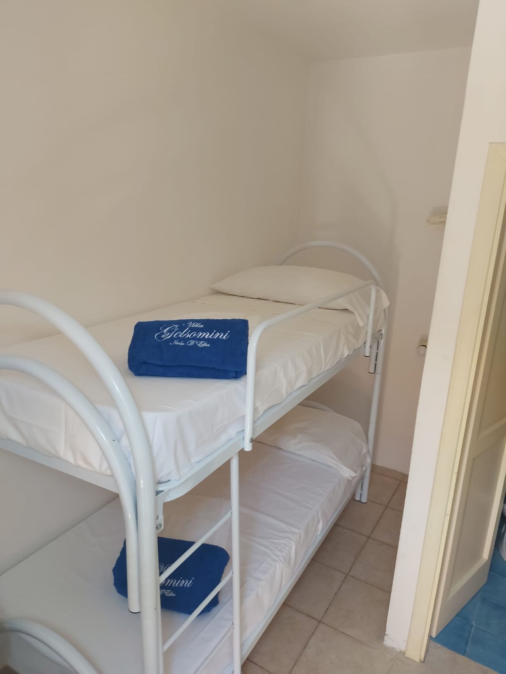 A bunk bed with a blue towel on the top bunk.