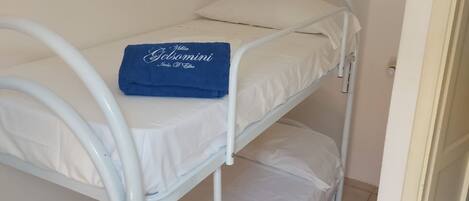 A bunk bed with a blue towel on the top bunk.