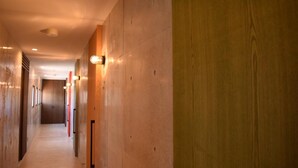 Un largo y estrecho pasillo con paredes de madera e iluminación empotrada.