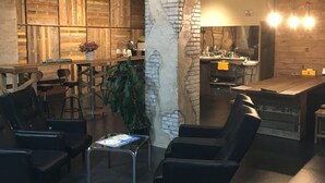 A modern interior with a bar area, seating, and a kitchen. - GUEST HOUSE MASAGO - Hostel (Urakawa)