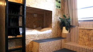 A bunk bed room with a wooden ladder, a small bench, and a potted plant. - GUEST HOUSE MASAGO - Hostel (Urakawa)
