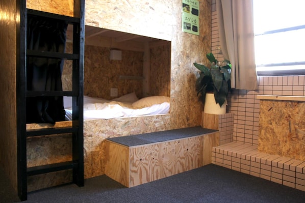 A bunk bed room with a wooden ladder, a small bench, and a potted plant. - GUEST HOUSE MASAGO - Hostel (Urakawa)