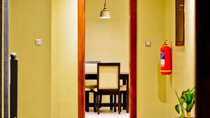 A hotel lobby with a reception desk, a fire extinguisher, and a potted plant. - Greendale Apartments (Kampala)