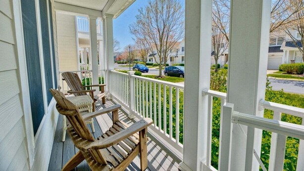A porch with two wooden Adirondack chairs and a white railing. - Bear Trap Dunes * 4BR Lovely Townhouse End Unit (Ocean View)