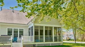 A house with a covered porch, a lawn, and a tree. - Bear Trap Dunes * 4BR Lovely Townhouse End Unit (Ocean View)