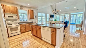 A spacious kitchen with wooden cabinets, a dishwasher, and a large island. - Bear Trap Dunes * 4BR Lovely Townhouse End Unit (Ocean View)