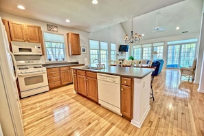 A spacious kitchen with wooden cabinets, a dishwasher, and a large island.