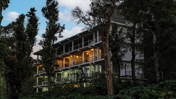 A multi-story building surrounded by dense vegetation. - Itsy Hotels Jammabane Cottage (Somvarpet)