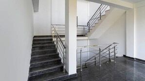A modern staircase with metal railings and dark marble steps. - Itsy Hotels Jammabane Cottage (Somvarpet)