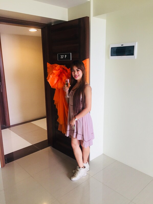 Une personne se tient dans un couloir, devant une porte portant l’inscription « 37 P ».