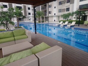 Un espace piscine moderne avec des chaises longues et une terrasse en bois.