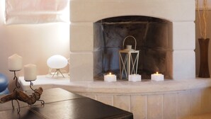 A fireplace with white candles and a decorative metal lantern. - Niko's Art villa (Chania)