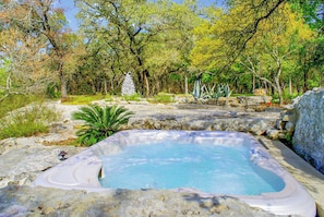 Un jacuzzi rodeado de rocas y árboles.